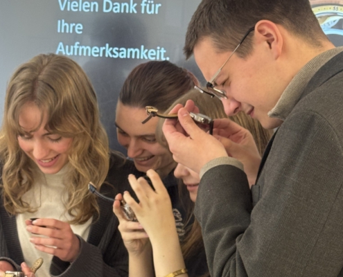 Mehrere Schüler sehen sich Armbanduhren an.