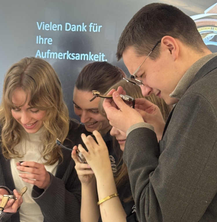 Mehrere Schüler sehen sich Armbanduhren an.