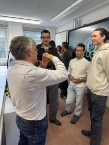 Herr Thomas Prescher erklärt Uhrmacherschülern seine Ideen.